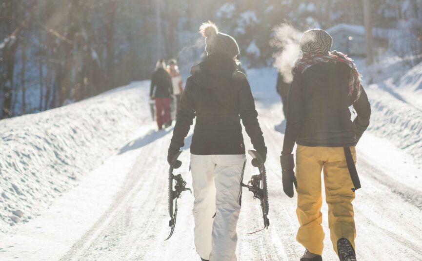 women walking with snow gear on