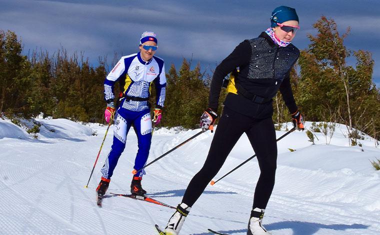 two cross-country skiers moving forward on the snow