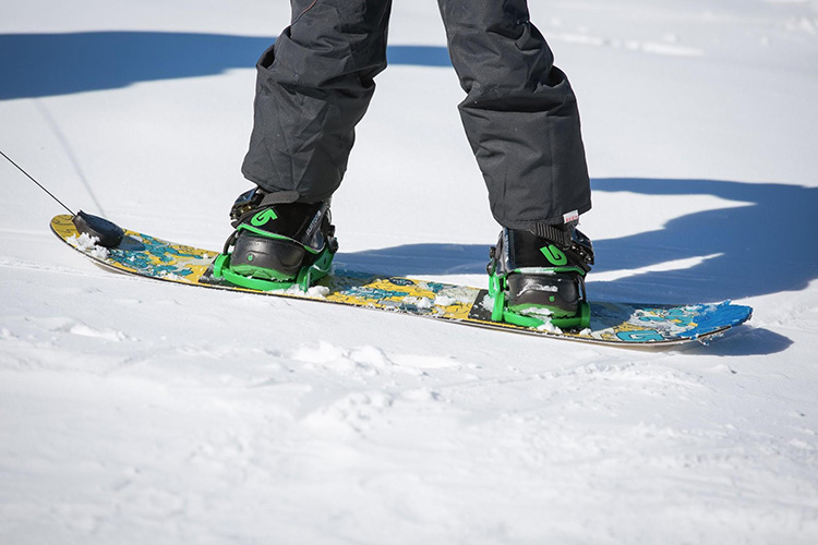 feet strapped into a snowboard